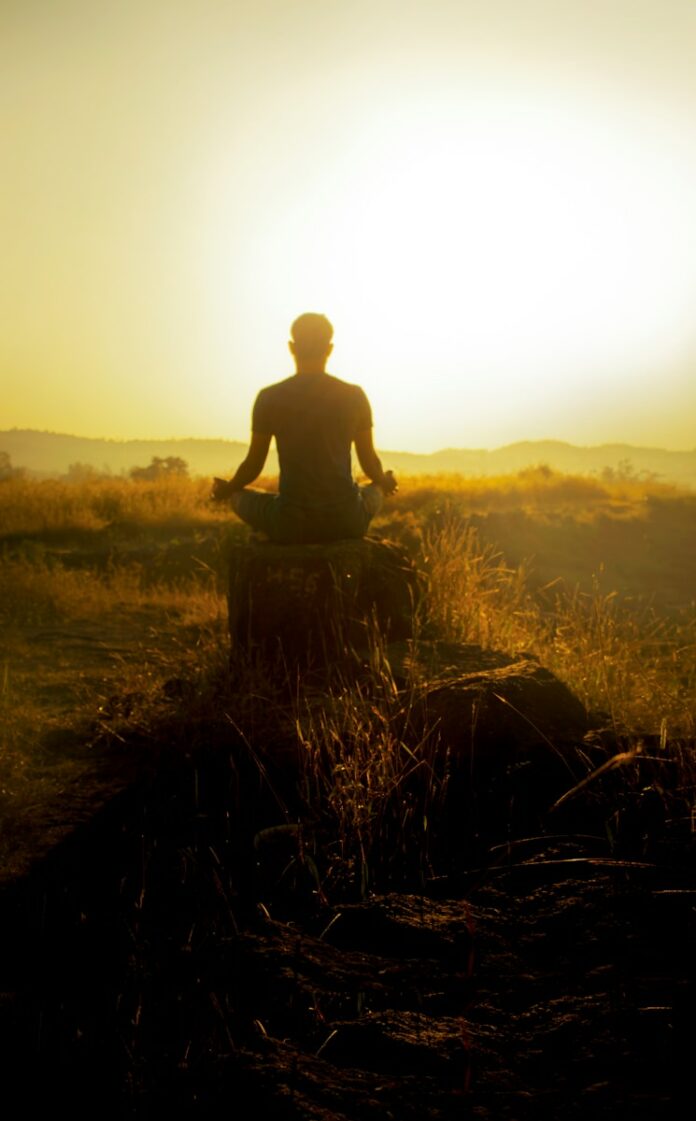 Photo by Anway Pawar man in black shirt sitting on brown grass during daytime