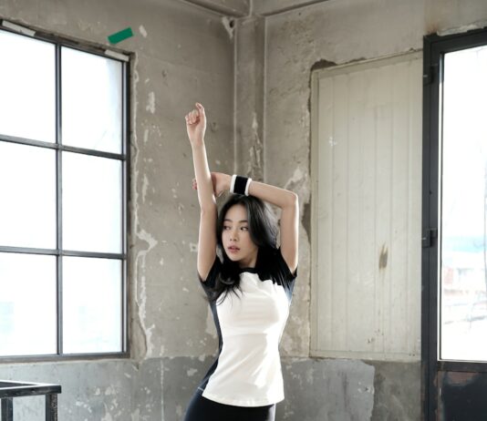 여름철 운동 후 빠른 회복을 위한 스트레칭 방법 woman in white shirt and black leggings standing near window