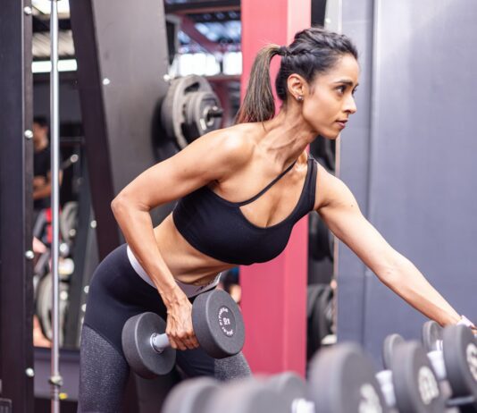 근력 운동과 유연성 향상: 밸런스 맞추기 위한 운동 루틴 A woman doing a squat with dumbbells in a gym