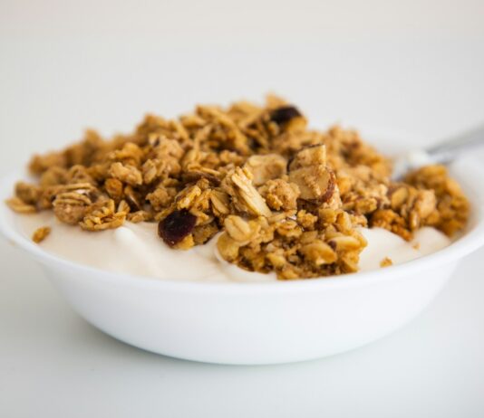 체중 감량에 도움이 되는 아침 운동과 식단 구성 a bowl of granola and yogurt with a spoon