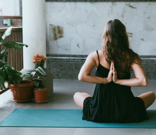 실내에서 즐기는 간단 요가 루틴 woman wearing black shirt sitting on green yoga mat