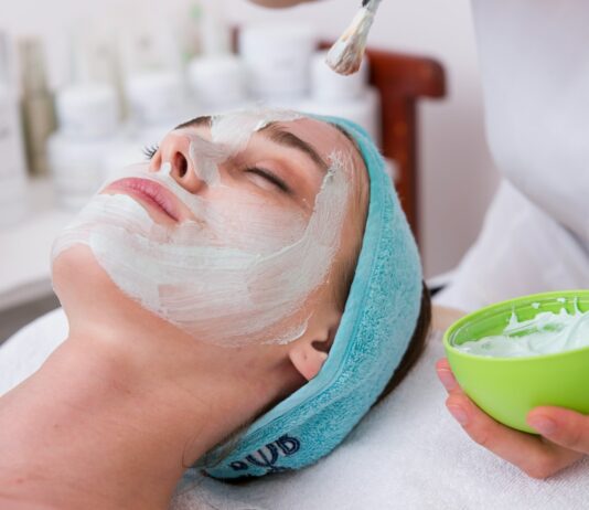 “피부과 다녀도 반복되는 트러블…” 결국 문제는 ‘클렌징 습관’일 수 있습니다 woman lying on blue towel with white cream on face