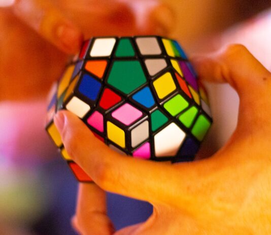 뇌 건강을 지키는 생활습관, 치매 예방의 첫걸음 person holding 3 x 3 rubiks cube