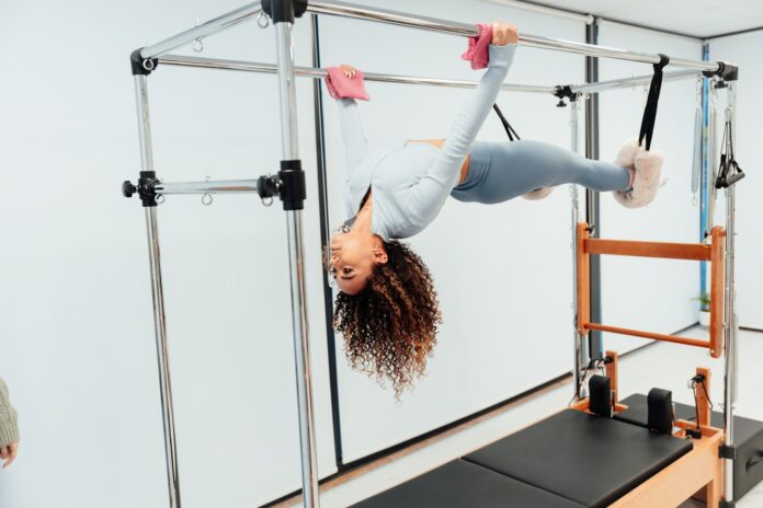 a woman doing a handstand on a parallel bar